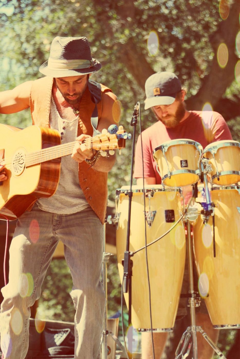 Soma playing guitar, with a percussionist behind