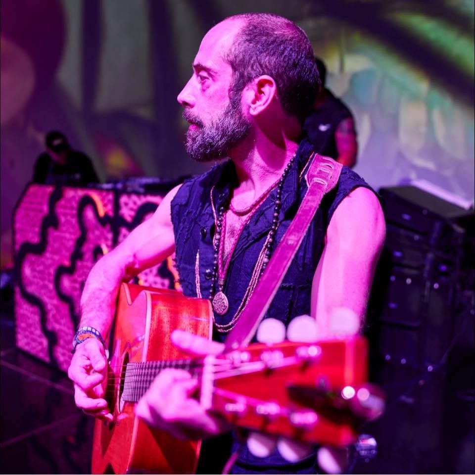 Soma on guitar under stage lights